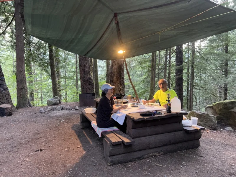 Rustic forest picnic area under a canopy at Sloquet Hot Springs
