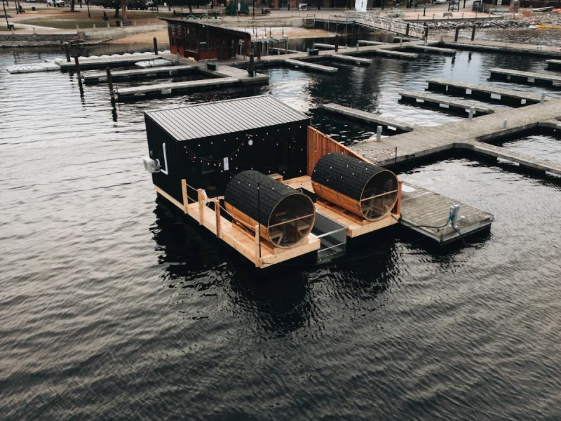 Aerial view of floating sauna platform in marina with city skyline